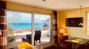 a room with a large window with a view of the ocean at Haus Am Strand in Breege