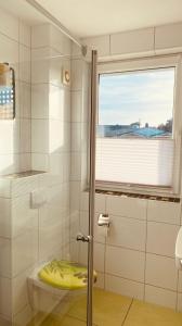 a bathroom with a shower with a toilet and a window at Haus Am Strand in Breege