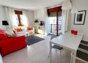 Una sala de estar con un sofá rojo y una mesa. en Masquestar Rías Altas, en Foz