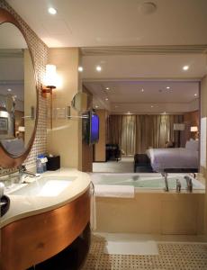 a bathroom with a tub and a bedroom with a bed at The Lakeview Hotel in Beijing