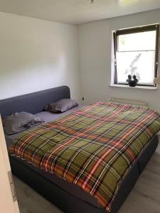 a bedroom with a bed with a plaid blanket on it at Wohnung mit Garten und überdachter Terrasse in Bremen