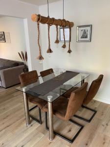 une salle à manger avec une table et des chaises en verre dans l'établissement Wohnung mit Garten und überdachter Terrasse, à Bremen