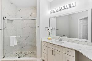 a white bathroom with a shower and a sink at The Epic Dublin Vista Cay Orlando in Orlando