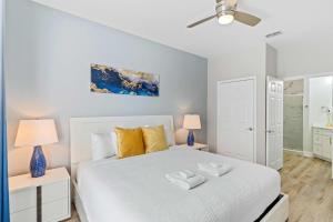 a bedroom with a white bed with two tables and two lamps at The Epic Dublin Vista Cay Orlando in Orlando
