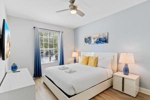 a white bedroom with a bed and a window at The Epic Dublin Vista Cay Orlando in Orlando