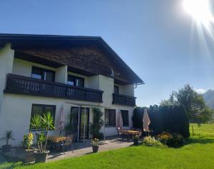 une maison avec un balcon, des tables et des chaises dans l'établissement Die Sonnenblume, à Sankt Kanzian