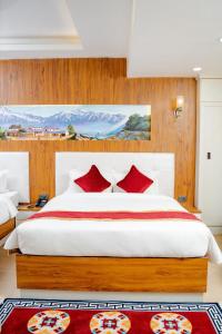 a bedroom with a large bed with red pillows at Hotel Palazzo in Kathmandu