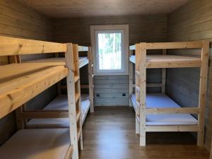 a room with three bunk beds in a cabin at Krivasalio sporto ir rekreacijos centras in Šiškiniai