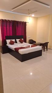 una camera da letto con un grande letto con tende rosse di VRS Residency a Mysore