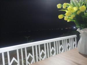a vase of flowers sitting on top of a balcony at Penginapan Lamban Queens Kamar Double Bed Standar Room in Kalianda +2 photos