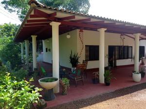 a patio with a pergola and a table and chairs at The Villa Hush in Hikkaduwa