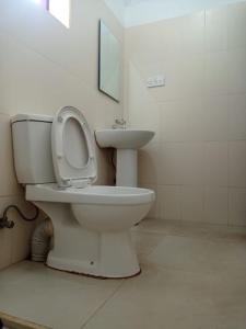 a bathroom with a toilet and a sink at The Villa Hush in Hikkaduwa