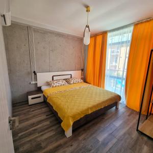 1 dormitorio con 1 cama grande y cortinas de color naranja en GiNa Shekvetili en Shekhvetili