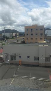 a large white building next to a parking lot at Apartamento inteiro in Serra