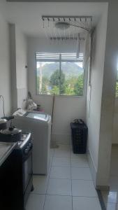 uma cozinha com um lavatório e uma janela em Apartamento inteiro em Serra