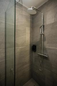 a shower with a glass door in a bathroom at Aristotelous Downtown Suites in Thessaloniki