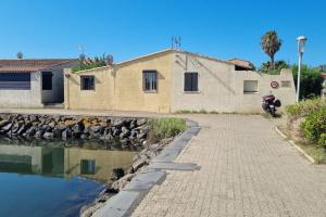 a building with a motorcycle parked next to a body of water at Au village naturiste, Villa vue Marina in Cap d'Agde