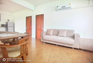 een woonkamer met een bank en een tafel bij YYK Townhouse in Ban Khlong Krang