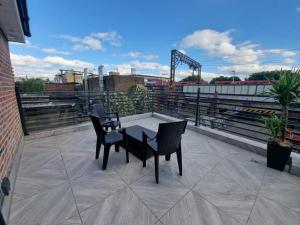 a patio with two chairs and a table on a roof at Stunning roof terrace studio flat in London