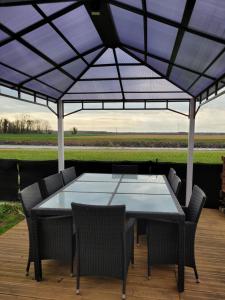 un tavolo e sedie sotto un ombrellone su un patio di Maison au bord du canal 