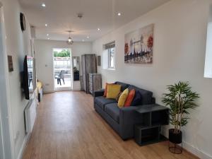 a living room with a couch and a tv at Stunning roof terrace studio flat in London