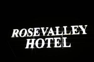 a sign that says rose valley hotel in the dark at Rose Valley Hotel in Ouarzazate