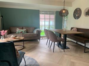 - un salon avec une table et un canapé dans l'établissement Boshof 5 in bosrijke, rustige omgeving!, à Ermelo