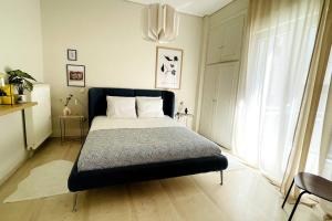 1 dormitorio con 1 cama en una habitación con ventana en Cybele apt downtown, en Volos