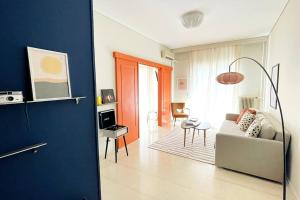 sala de estar con sofá blanco y pared azul en Cybele apt downtown, en Volos