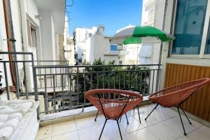 - Balcón con 2 sillas y sombrilla en Cybele apt downtown, en Volos