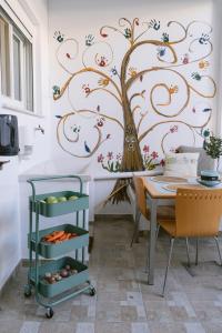a dining room with a tree mural on the wall at Armonia-Art House in Kos