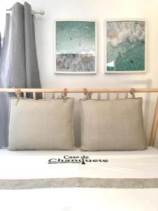 duas almofadas numa cama com duas fotografias na parede em Casa de Chanquete em Viana do Castelo