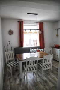 uma sala de jantar com uma mesa de madeira e cadeiras em Brockensicht em Ilsenburg