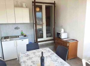 a kitchen with a table with a bottle of wine on it at Apartment Nadallina in Jelsa