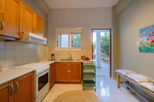 a kitchen with wooden cabinets and a sink at Armonia-Art House in Kos +44 photos