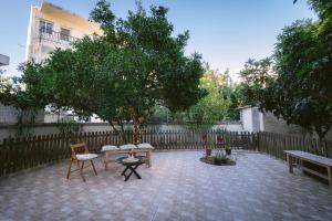 a patio with two chairs and a table and trees at Armonia-Art House in Kos