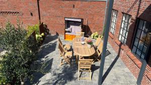 a patio with a table and chairs in front of a brick building at Loftwohnung in charmantem Hinterhof direkt in Grachtnähe und Treene in Friedrichstadt