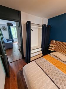 a bedroom with a bed and a blue wall at 2 pièces, SPA et terrasse, Nancy Thermal in Nancy