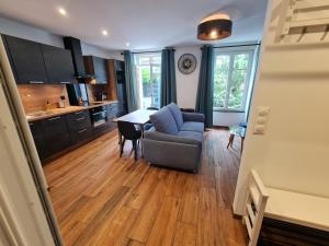 a kitchen and living room with a couch and a table at 2 pièces, SPA et terrasse, Nancy Thermal in Nancy