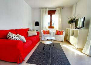 a living room with a red couch and two chairs at Masquestar Rías Altas in Foz