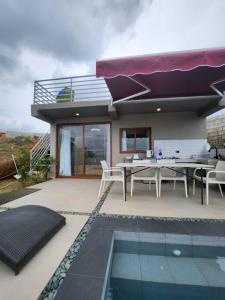 a house with a table and chairs and a swimming pool at Skypad at the Observatory in Antipolo