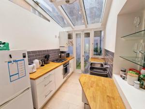 a kitchen with white appliances and a skylight at Beautiful Hyde Park Flat by Lancaster Gate Station with Private Back Patio in London