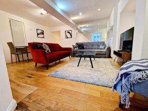 a living room with a couch and a red chair at Beautiful Hyde Park Flat by Lancaster Gate Station with Private Back Patio in London