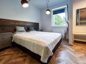a bedroom with a large bed and a window at Apartament Centrum B in Wejherowo