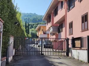 einen Eingang zu einem rosa Gebäude mit einem Tor in der Unterkunft Come a casa in Monsummano