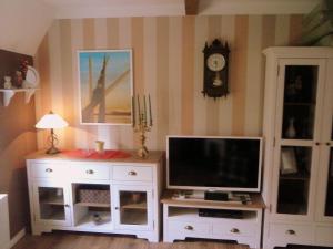a living room with a tv and a white entertainment center at Am Schiefen Turm in Bad Frankenhausen