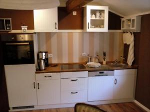 a kitchen with white cabinets and a sink at Am Schiefen Turm in Bad Frankenhausen
