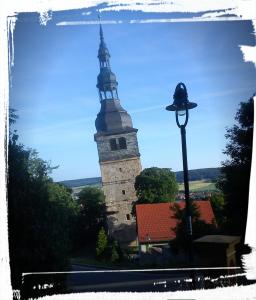 una torre alta con un campanario en la parte superior de un edificio en Am Schiefen Turm, en Bad Frankenhausen