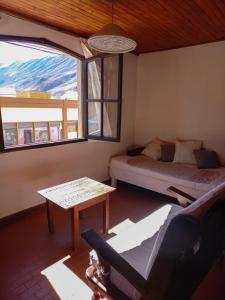 Habitación con cama, mesa y ventana en Departamento Centrico en Tilcara en Tilcara