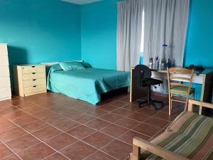 a bedroom with a bed and a desk and a chair at Encanto Natural de Arinaga in Arinaga